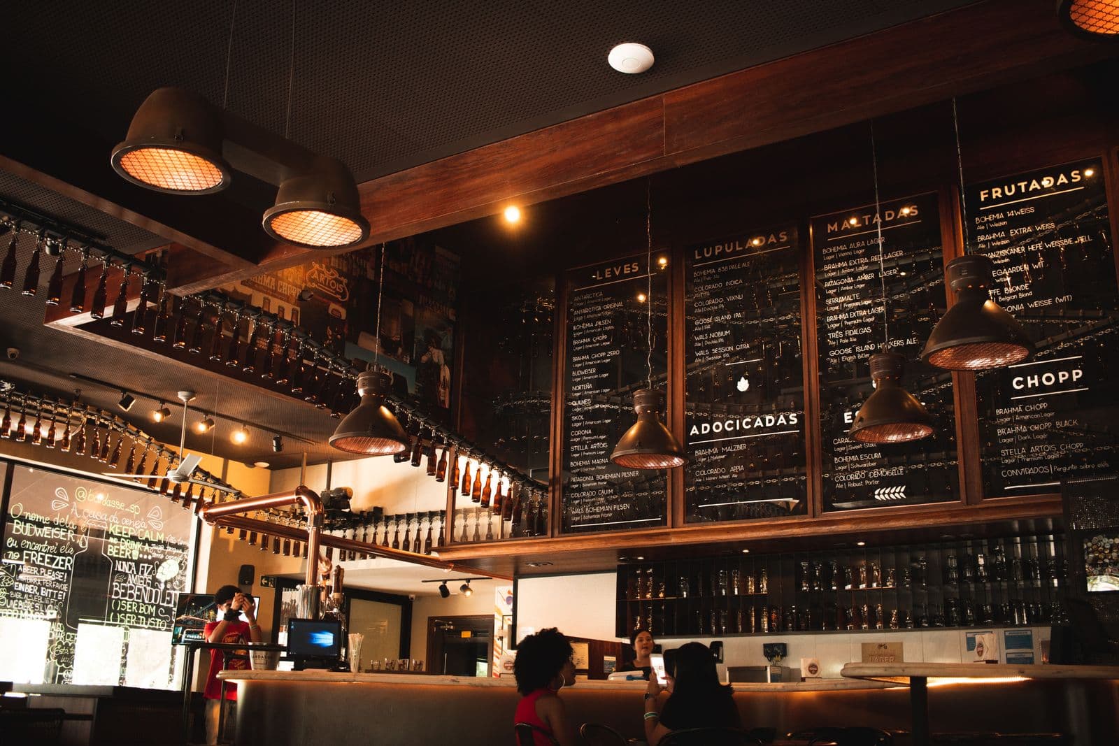 Restaurant bar with a chalkboard menu of prices under warm pendant lighting
